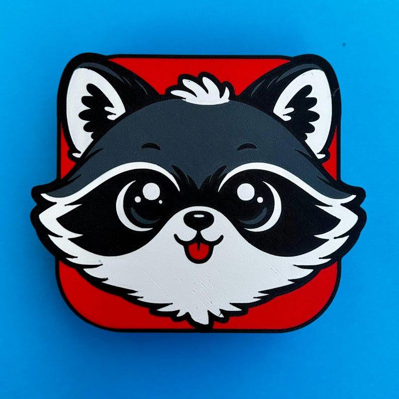 May include: A cartoon raccoon face with large eyes, a black mask, and a red tongue, set against a red square. The raccoon is primarily black and white, with a small tuft of white hair. The background is a solid blue.