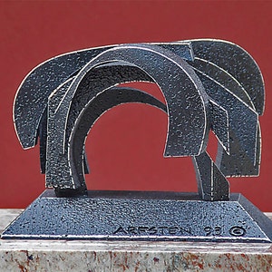 May include: A silver metal sculpture of abstract shapes, with a base that reads "JARSTEN 93 ©".