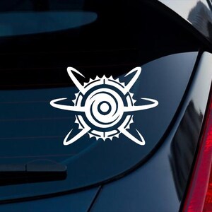 May include: A white vinyl decal featuring a stylized circular emblem with a central dot, surrounded by a serrated gear-like ring and four curved, orbital-like lines extending outward, applied to the rear window of a dark-colored vehicle.