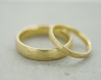 Pair of yellow gold wedding rings made from fair trade or recycled material with a hammer finish