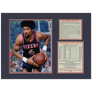 May include: Framed photo of Julius Erving, also known as Dr. J, in a Sixers jersey holding a basketball. The image includes text about his Hall of Fame induction and career statistics. The frame is black with red and white accents.