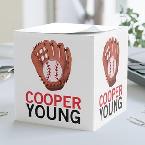 May include: White cardboard box with a baseball glove and baseball graphic. The box has the text "COOPER YOUNG" printed in red and black.