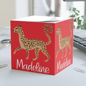 May include: Red notepad with a cheetah illustration and the name "Madeline" printed on the front.