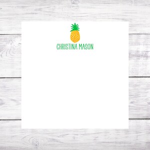 May include: White notepad with a green pineapple illustration and the text "Christina Mason" printed in green.