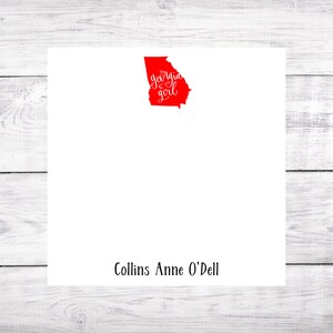 May include: White stationery card with a red outline of the state of Georgia and the text "Georgia girl" in red cursive. The name "Collins Anne O'Dell" is printed in black at the bottom of the card.