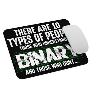 Op de afbeelding: Zwart rechthoekig muismat met de tekst "THERE ARE 10 TYPES OF PEOPLE WHO UNDERSTAND BINARY AND THOSE WHO DON'T...." in het wit. Een witte draadloze muis ligt rechts.
