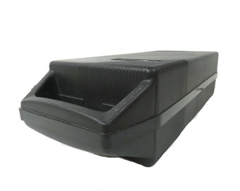 May include: A black plastic carrying case with a handle. The case has a textured surface and a black latch.