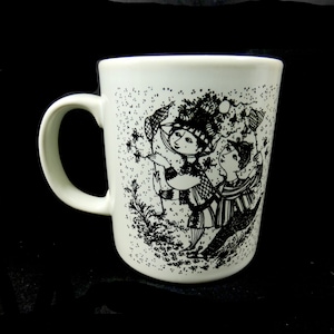 Puede incluir: Taza de cerámica blanca con una ilustración en blanco y negro de dos personas bailando. La ilustración está rodeada de un patrón de pequeños puntos negros.