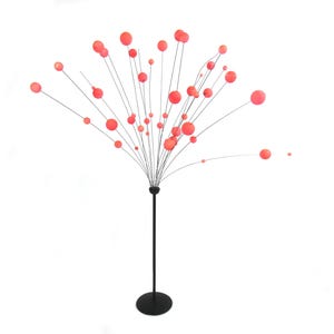 Pode incluir: Uma luminária de chão moderna com base e haste pretas, apresentando numerosos fios finos prateados que se estendem para fora. Cada fio termina em uma esfera redonda de cor coral, criando uma luminária artística única. As esferas variam em tamanho.