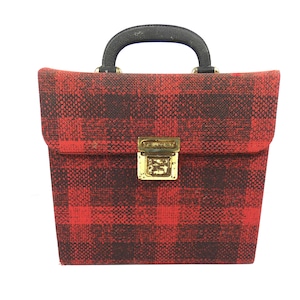 May include: A red and black plaid vintage suitcase with a black handle and a gold latch.