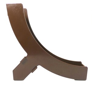 May include: A brown metal plant stand with a curved design. The stand has a wide base and a curved top that is open on one side.