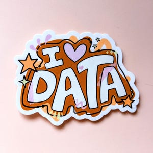 Puede incluir: Una pegatina con las palabras "I ❤️ DATA" en blanco, delineadas en negro, sobre un fondo marrón. El corazón es rosa, y el diseño incluye estrellas naranjas y elementos decorativos. La pegatina tiene un borde blanco irregular.