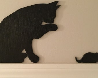 Cat licking paw with mouse