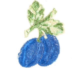 Può includere: Toppa ricamata con due prugne blu con un gambo di foglia verde.