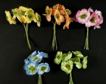 May include: Six bunches of artificial flowers, each with a different color. The colors are yellow, orange, pink, blue, and green. The flowers are all in the shape of poppies.