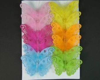 May include: Assortment of eight colorful butterfly cutouts with a lacy design. The butterflies are arranged in a stack, with the largest butterfly at the bottom and the smallest butterfly at the top. The butterflies are made of a soft, feathery material and have a variety of colors, including pink, blue, green, yellow, and orange.