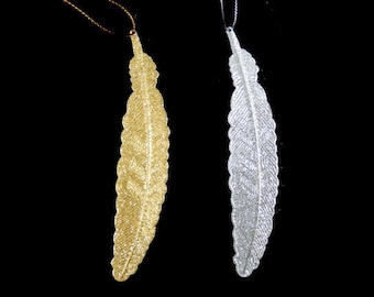 May include: Two decorative feather ornaments, one gold and one silver, hanging from strings. The feathers are made of a sparkly material.
