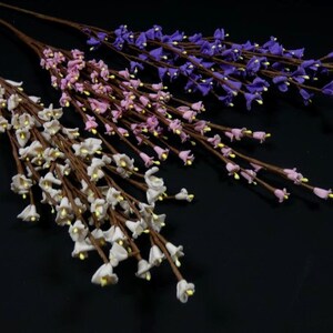 May include: Three sprigs of artificial flowers with small bell-shaped blooms. The flowers are white, pink, and purple.