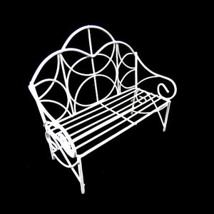 Könnte beinhalten: Weiße Gartenbank aus Metall mit dekorativem, geschwungenem Design. Die Bank hat eine Sitzfläche mit Latten und eine geschwungene Rückenlehne.