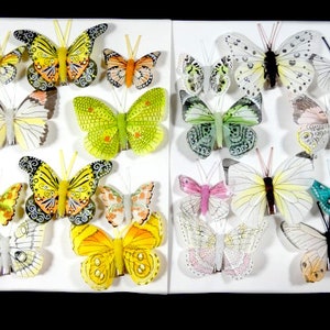 May include: Assortment of colorful butterfly embellishments with various wing patterns and colors, including yellow, green, blue, pink, and white. These decorative butterflies are perfect for adding a touch of whimsy to crafts, scrapbooking, and other projects.
