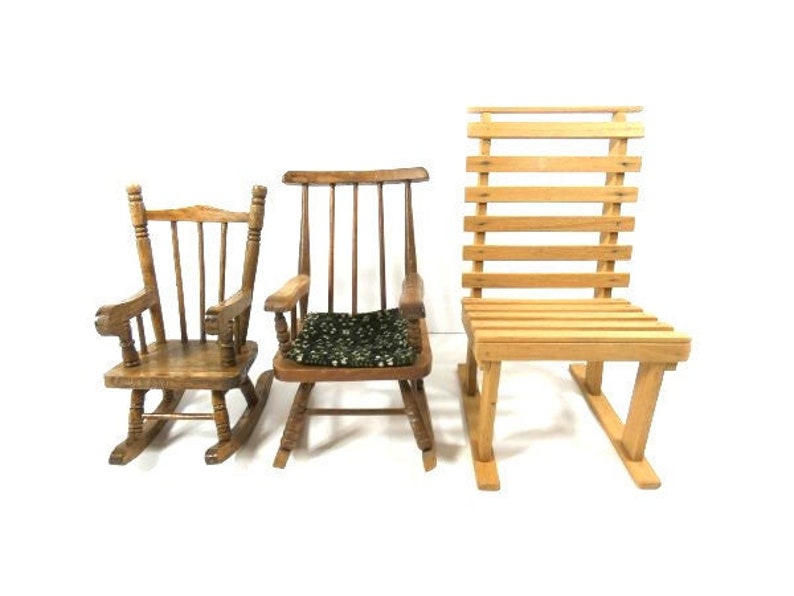 Puede incluir: Tres sillas de madera, una mecedora con un coj&iacute;n verde, una mecedora con respaldo de listones y una silla con respaldo de listones.