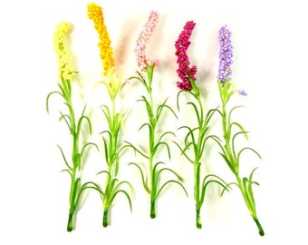 Könnte beinhalten: Fünf künstliche Blumenstiele mit grünen Blättern und unterschiedlichfarbigen Blütenköpfen. Die Blütenköpfe sind gelb, rosa, lila und rot.