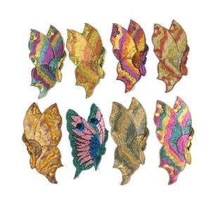 Puede incluir: Diez parches bordados de mariposa en varios colores, incluyendo rosa, azul, verde, amarillo y naranja. Las mariposas tienen un aspecto texturizado y en capas.