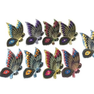 Puede incluir: Diez parches de mariposa bordados en varios colores, incluyendo azul, morado, rojo y dorado. Las mariposas tienen alas negras con detalles coloridos y un acabado brillante.