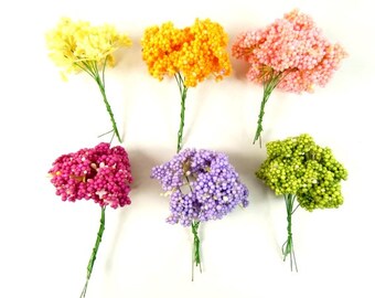 Puede incluir: Seis ramos de flores artificiales con pequeñas flores redondas. Los ramos son de varios colores, incluyendo amarillo, rosa, morado, verde y rojo.