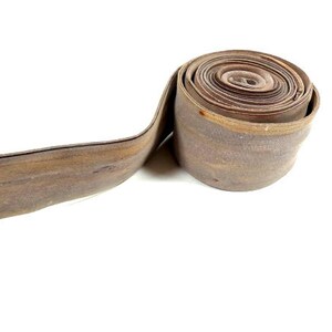 May include: A roll of brown leather trim, coiled and ready to be used for crafting projects.