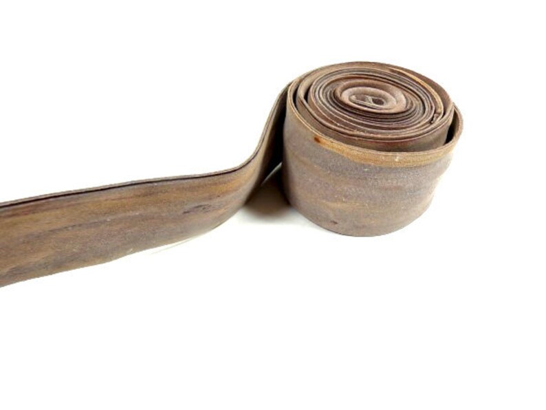 May include: A roll of brown leather trim, coiled and ready to be used for crafting projects.
