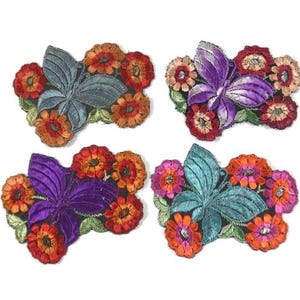 Puede incluir: Cuatro parches bordados para planchar con mariposas rodeadas de flores de colores. Las mariposas son en tonos de morado, azul verdoso y azul. Las flores son en tonos de rojo, naranja y amarillo.