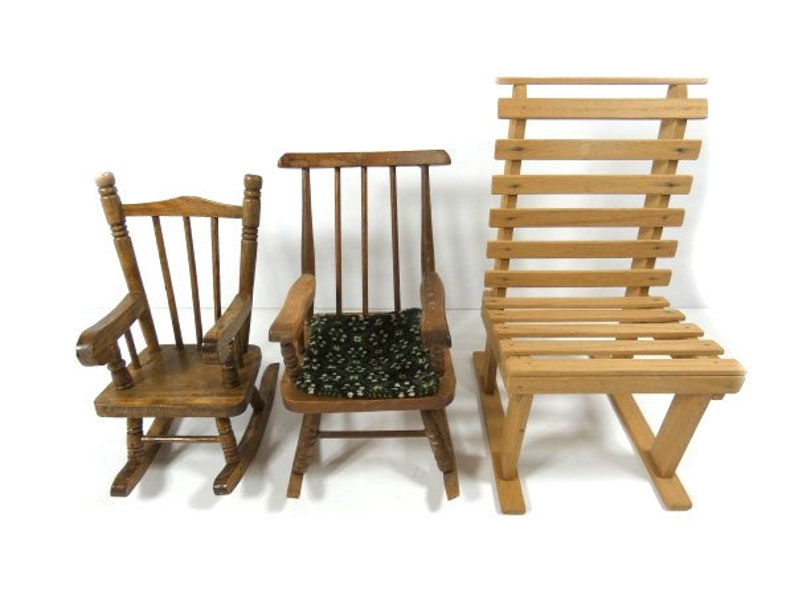 Puede incluir: Tres sillas de madera, una mecedora con un coj&iacute;n estampado en verde y negro, una mecedora con respaldo de listones y una silla con respaldo de listones.