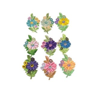 Puede incluir: Surtido de ocho parches de flores bordadas en varios colores, incluyendo rosa, azul, morado, amarillo y verde. Los parches presentan una sola flor grande con flores más pequeñas y hojas que la rodean.