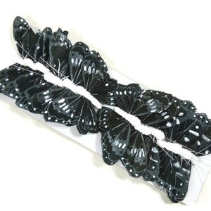 May include: A package of black butterfly wings for crafting. The wings are made of fabric and have a realistic look.