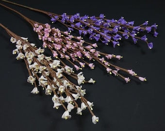 May include: Three artificial flower stems with small bell-shaped flowers. The stems are brown and the flowers are white, pink, and purple.