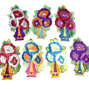 Peut inclure: Ensemble de huit patchs brodés thermocollants représentant des bouquets de fleurs colorés dans des vases. Les fleurs sont dans des tons de rouge, blanc, bleu, violet et orange. Les vases sont dans des tons de violet, jaune, orange et bleu.