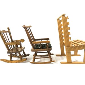 Puede incluir: Tres sillas de madera, dos mecedoras y un banco. Las mecedoras son de madera oscura y tienen respaldo y asiento de listones. El banco es de madera m&aacute;s clara y tiene respaldo y asiento de listones.