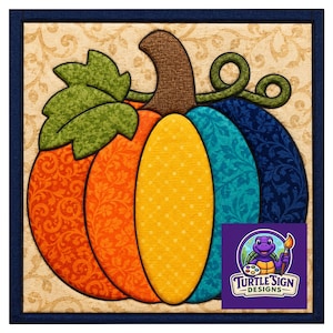 Puede incluir: Una pieza de arte mural cuadrada que presenta una calabaza estilizada con segmentos en naranja, amarillo y azul, cada uno con patrones distintos. Una hoja y un zarcillo verdes se sitúan sobre la calabaza, que tiene un tallo marrón. El logotipo Turtle Sign Designs es visible.