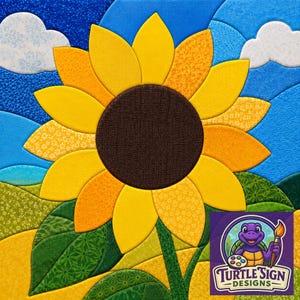 Puede incluir: Una pieza de arte en tela que muestra un gran girasol con un centro marrón oscuro y pétalos amarillos sobre un cielo azul con nubes blancas y colinas verdes. La esquina inferior derecha muestra un logo de tortuga morada con el texto Turtle Sign Designs.