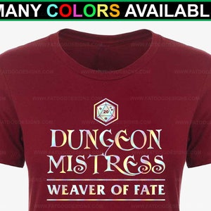 Könnte beinhalten: Burgunderfarbenes T-Shirt mit einer goldenen Grafik eines zwanzigseitigen Würfels und dem Text "Dungeon Mistress Weaver of Fate".