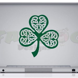 Op de afbeelding: Een groene klaver met een Keltisch knoopontwerp op een zilveren laptop.