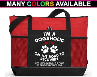 May include: A red and black tote bag with a white graphic that says "I'm a Dogahollic on the road to recovery. Just kidding, I'm on the road to rescue another dog."