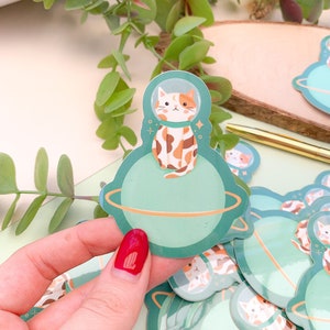 Brûlée le chat de l'espace - autocollant vinyle brillant | Autocollants, planète, papeterie, céleste, kawaii, chat, art numérique
