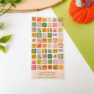 Peut inclure: Une feuille d'autocollants carrés colorés avec diverses illustrations, notamment des fournitures d'art, des arcs-en-ciel et des personnages mignons. Les autocollants sont disposés en grille. Le texte "Laurel Mae Art Illustration" est en bas.