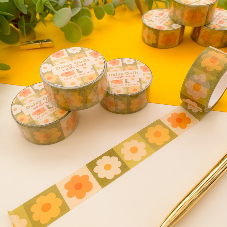 May include: Four rolls of green and yellow floral washi tape with the text "Daisy Quilt washi tape Laurel mae art" printed on each roll.