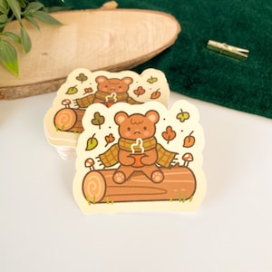 Ours douillet - Autocollant en vinyle mat | Art numérique, Stickers, drôle, Illustration, kawaii, Papeterie, mignon, confortable, hiver, animal, ours, feuilles