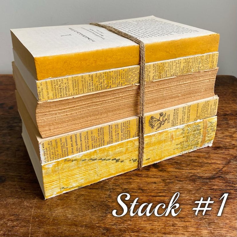 May include: A stack of vintage books with yellowed pages and brown covers, tied together with twine. The books are stacked on a wooden surface. The text on the top book reads "Commonwealth Literature".