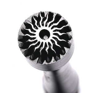 Peut inclure: Un tampon en métal avec un motif de soleil. Le tampon a une tête circulaire avec un motif de soleil en relief et un manche cylindrique.