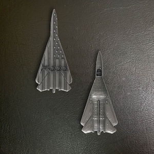以下が含まれることがあります： 銀製のF-14トムキャット戦闘機レプリカ2機。1機はアメリカ国旗のデザイン、もう1機は無地の銀製です。
